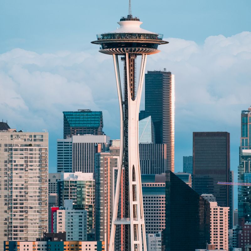 The image features the Space Needle against a backdrop of modern skyscrapers, symbolizing the skyline of Seattle, Washington.