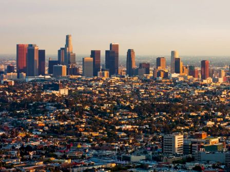 This image features a city skyline during the daytime, with numerous skyscrapers and buildings surrounded by a densely populated urban area.