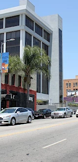 A street scene with parked cars, a red building labeled 